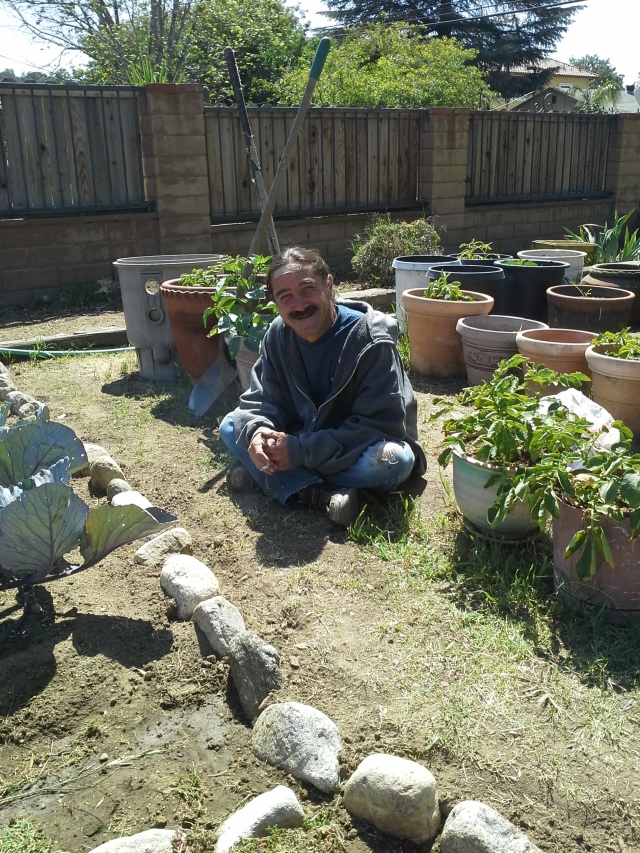 Dave - taking a break from pulling up rocks, digging up grass and replacing the rock borders of the gardens.